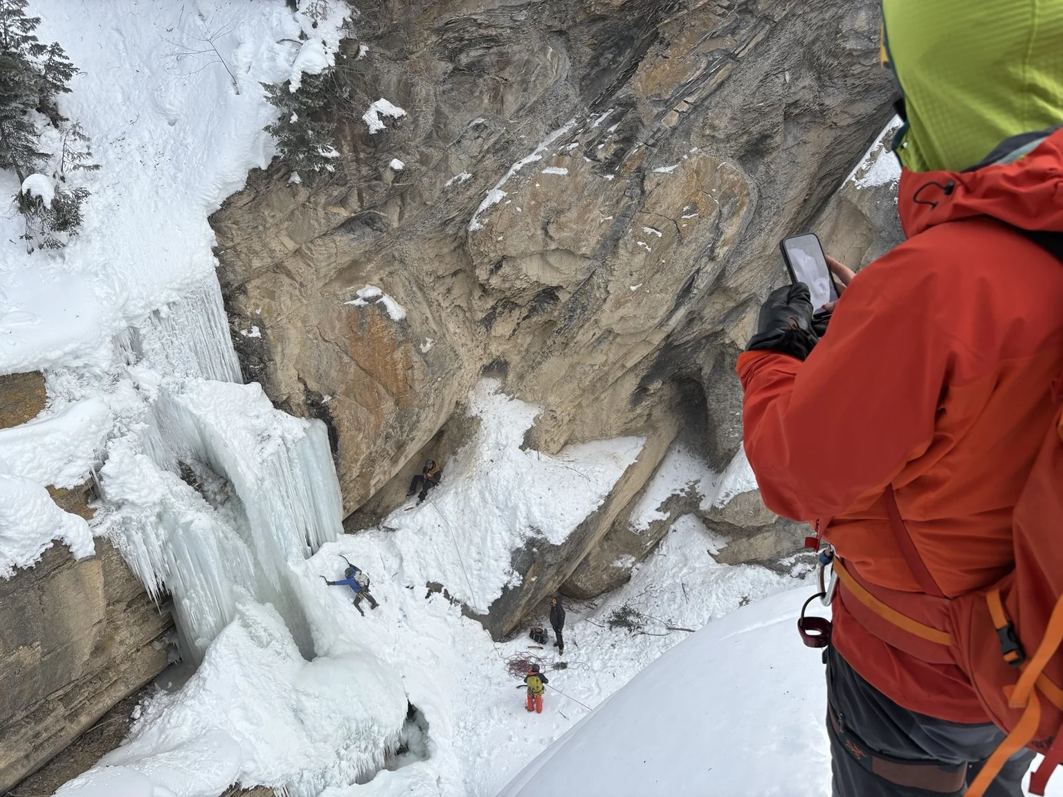 Roped climbers in a snow-filled rocky canyon