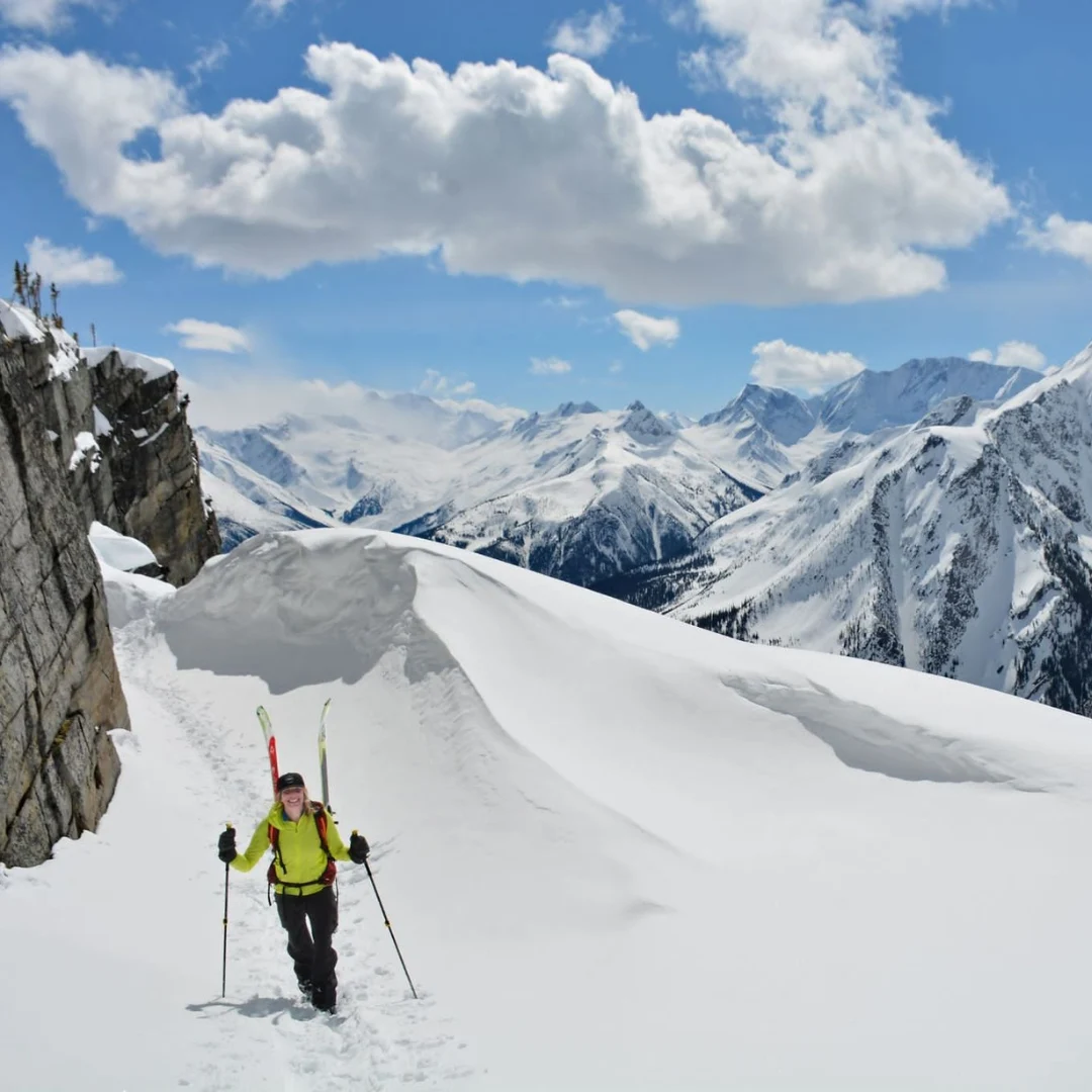Ski tourer crossing an open slope among snowy peaks