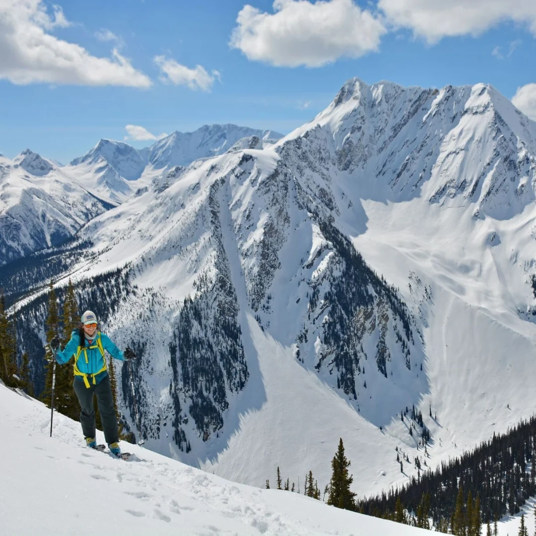 Ski tourer beneath a snow-covered mountain ridge