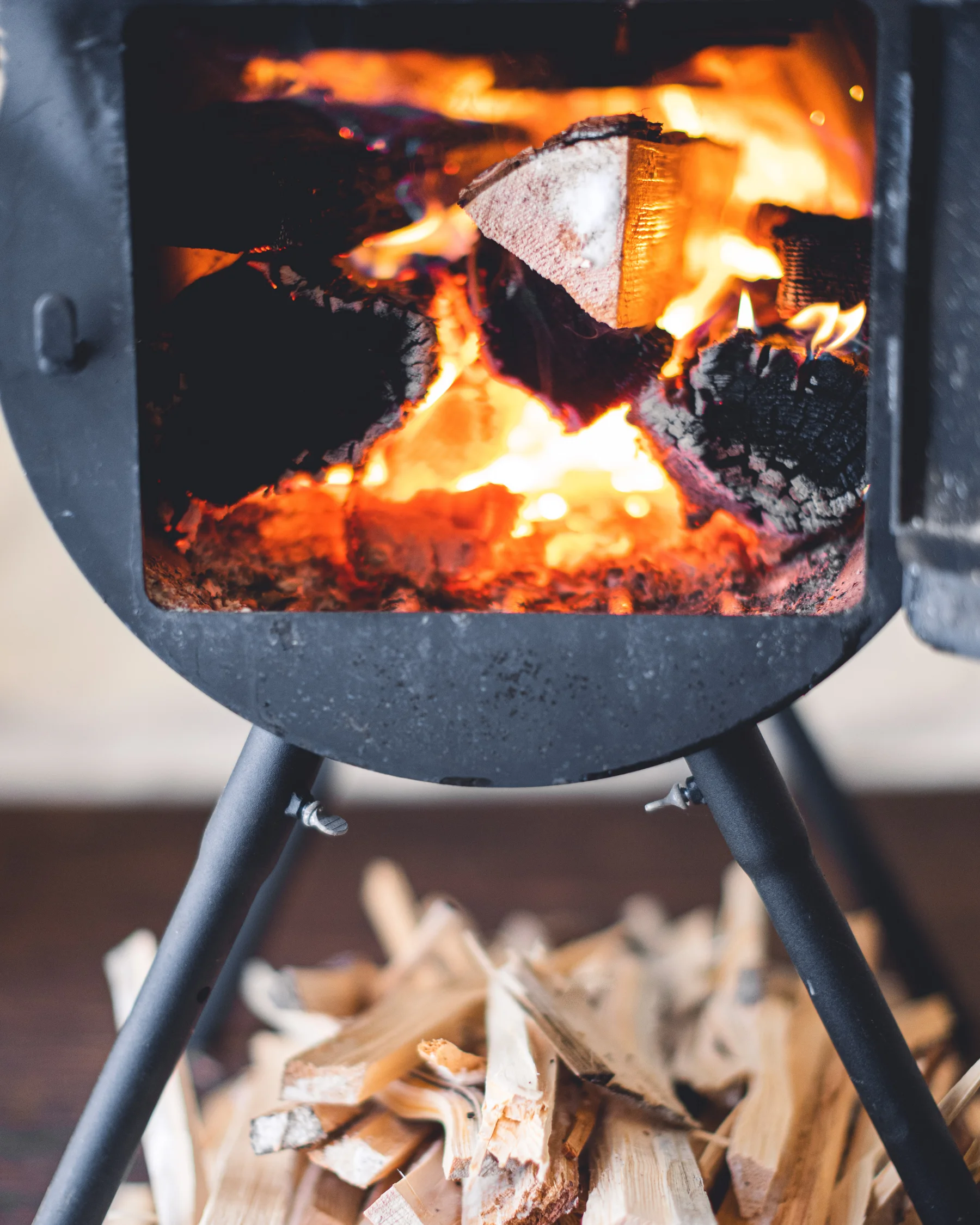 Logs burning brightly in a wood stove at camp